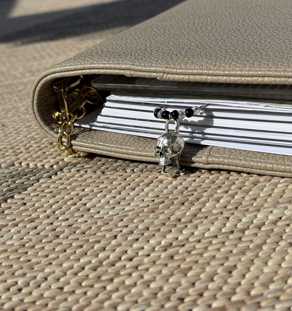 Side view of the Silver Skull & Black Bead Planner Clip in a planner