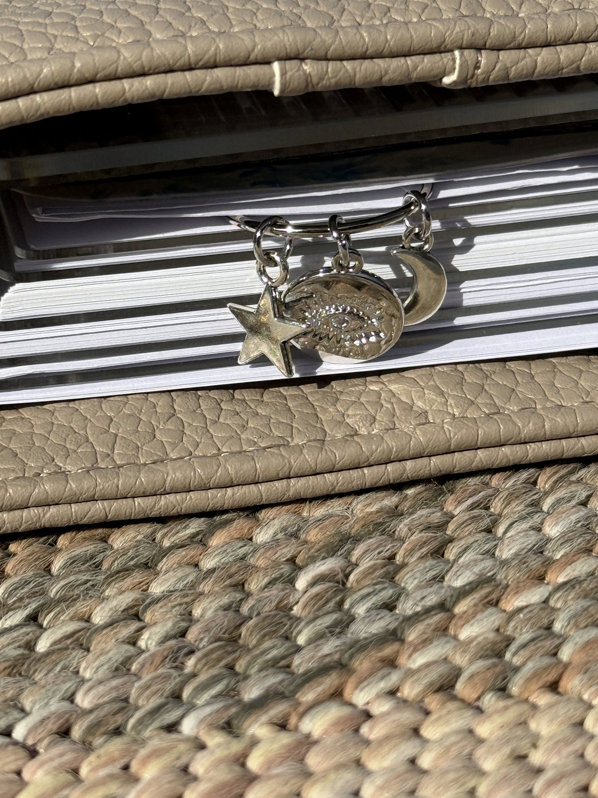 Close-up of the Evil Eye Coin Star & Moon Planner Clip clipped onto a planner page
