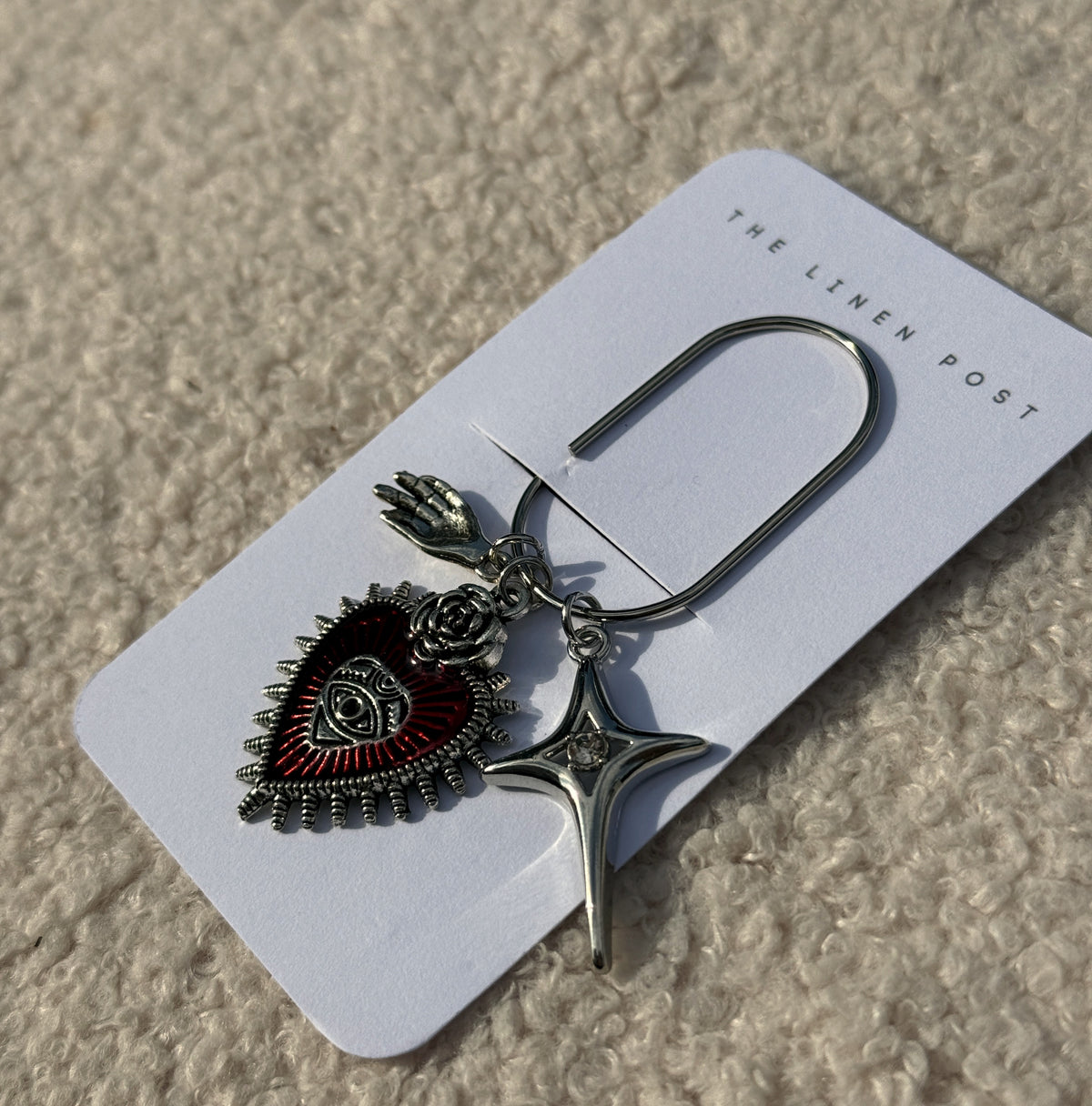 Red Sacred Heart & Star Planner Clip shown at an angle on its card
