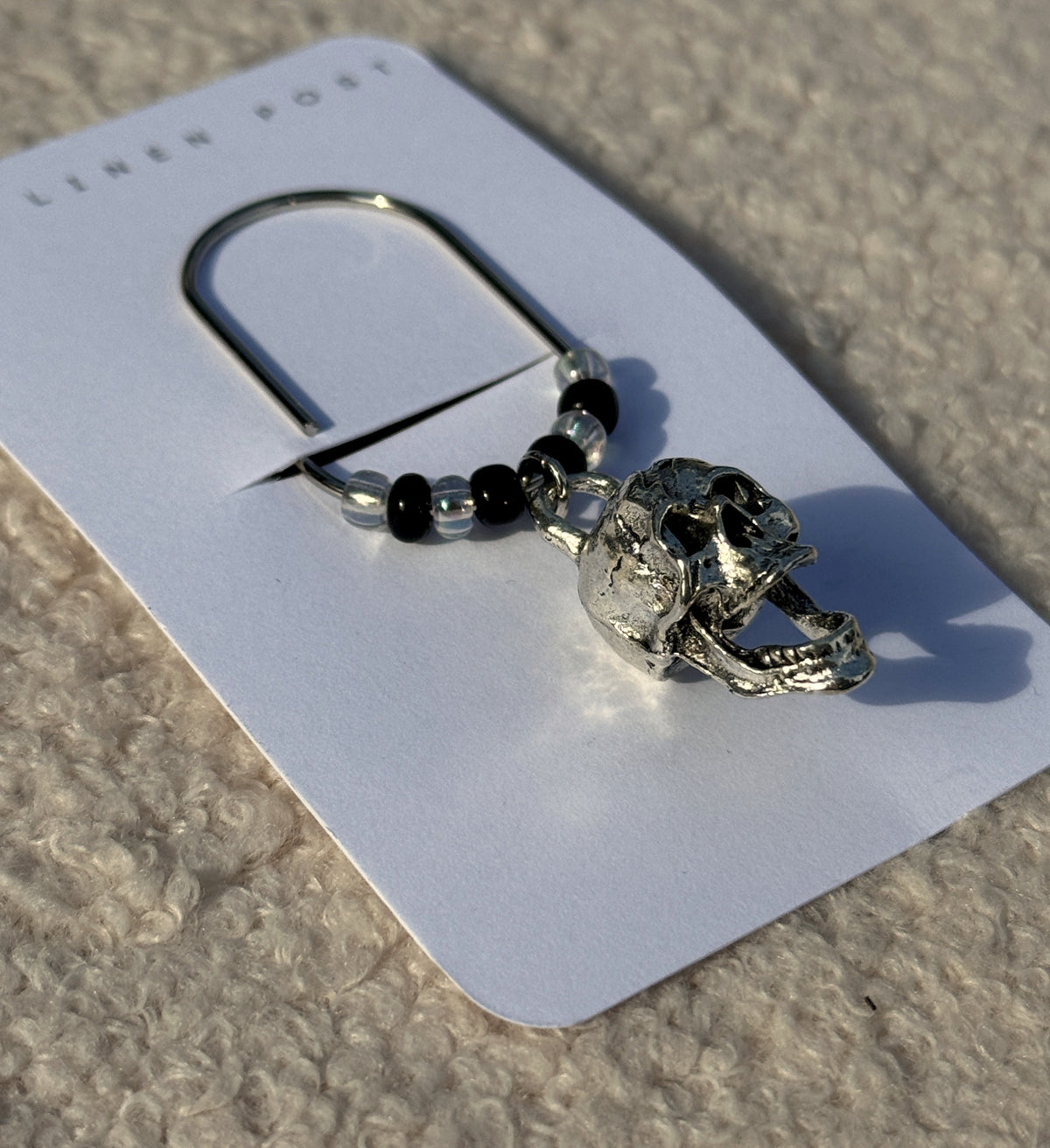Close-up of the silver skull charm and black and clear beads