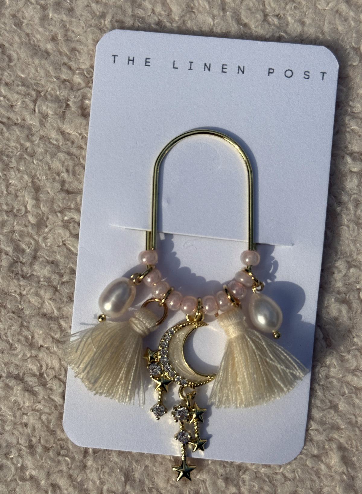 Front view of the Tassel Moon & Star Planner Clip in gold on its card